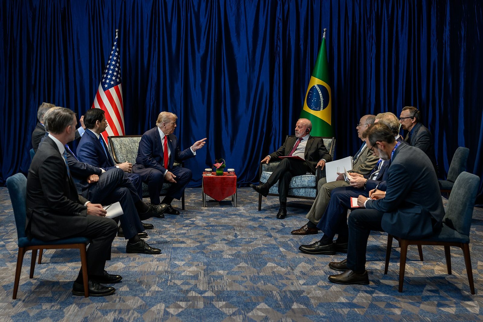 President Trump meets Brazilian President Luiz Inacio Lula da Silva, with U.S. and Brazilian flags behind them, in Kuala Lumpur in October 2025.