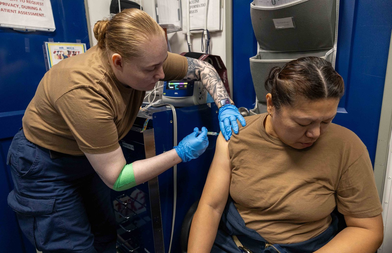 U.S. Navy Hospital Corpsman administering a vaccine to a crew member aboard USS George H.W. Bush