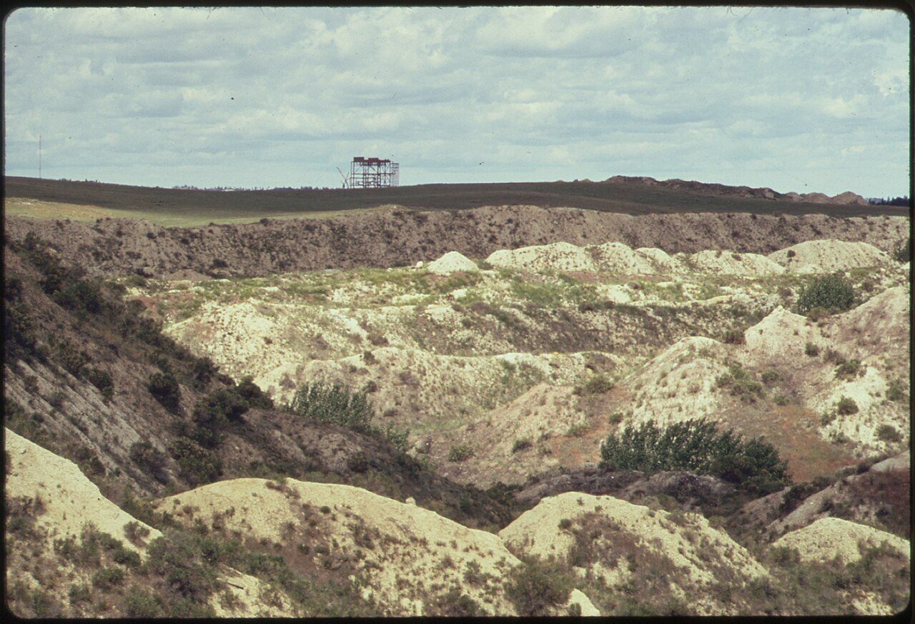 A large coal-fired power plant beside strip-mine spoil piles.