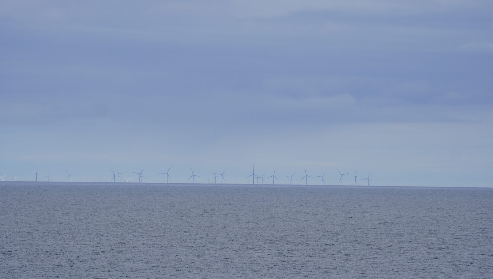Offshore wind turbines lined along the horizon of the North Sea