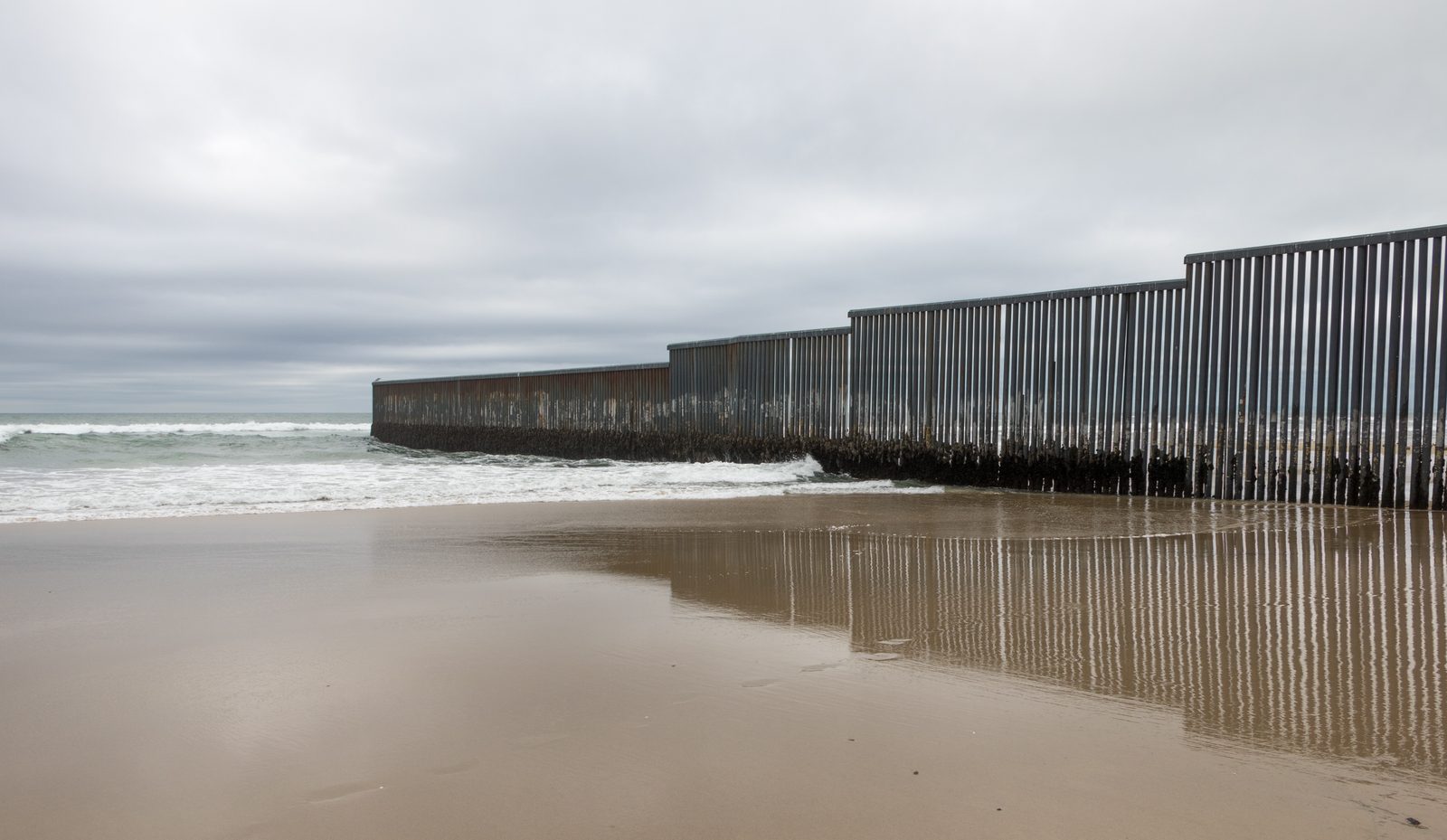 Mexico-US border fence at Tijuana with crosses marking migrant deaths
